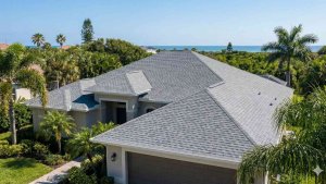 Aerial view of a luxury home in Melbourne FL with a new architectural shingle roof installed by Platinum Roofing.